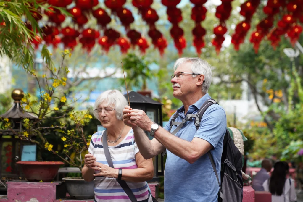 Tourists offering incense at Jade Emperor Temple in Saigon.